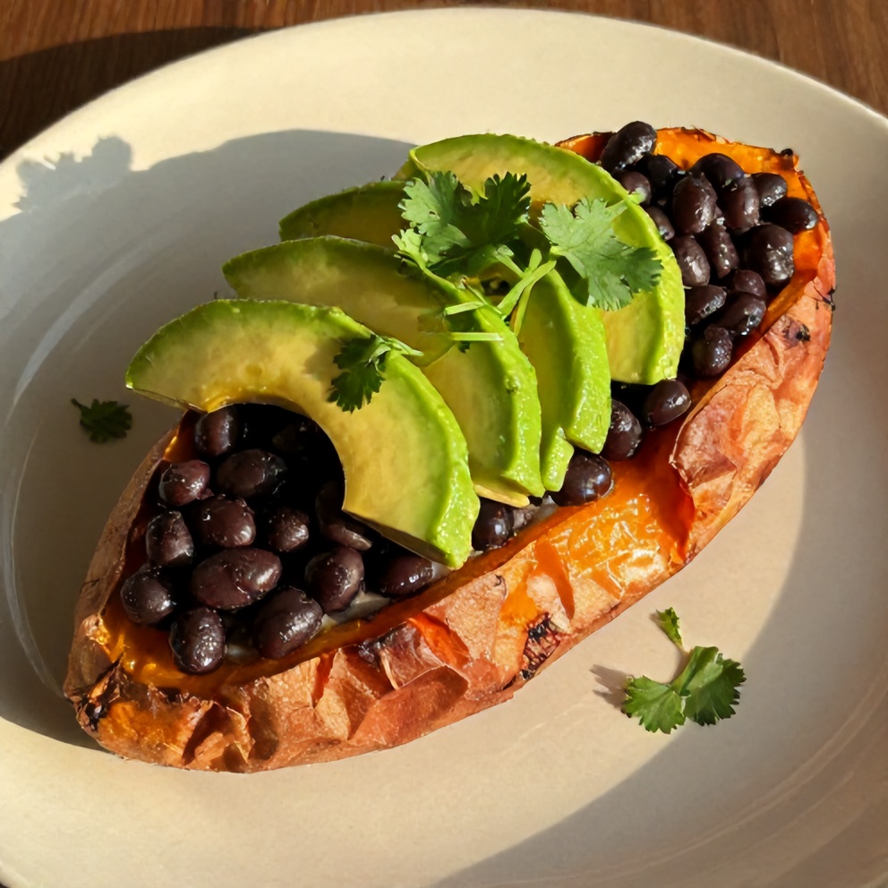 Plated Black Bean Stuffed Sweet Potatoes with avocado and cilantro