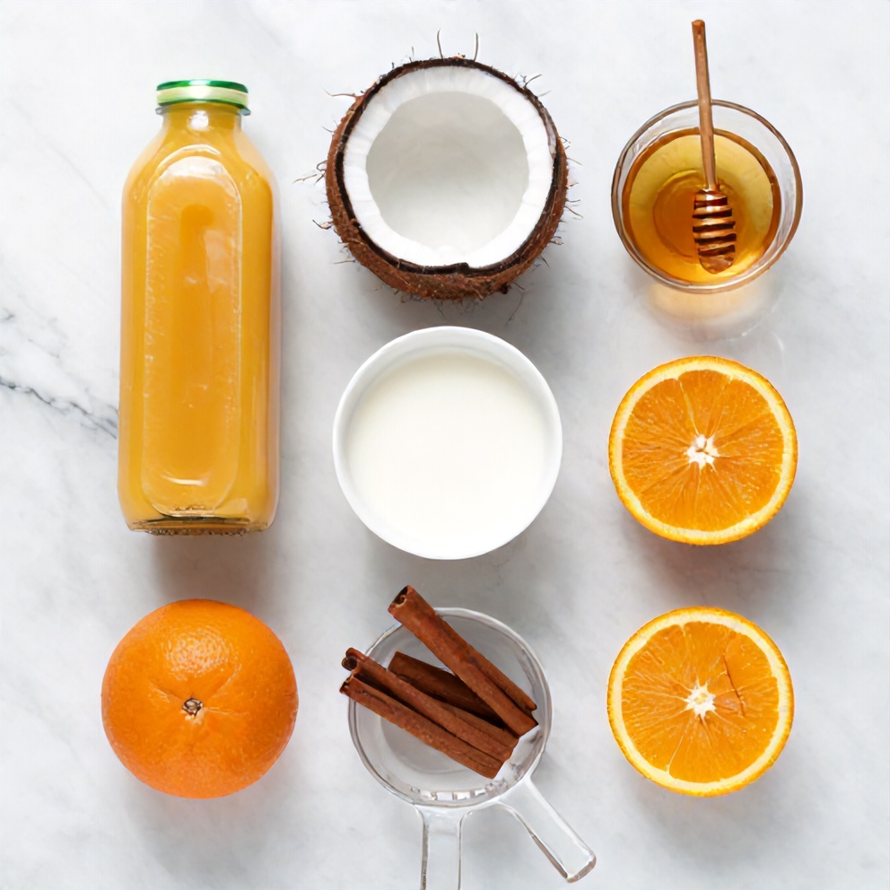 Raw ingredients for Creamy Coconut Orange Bliss Drink arranged in a flat lay