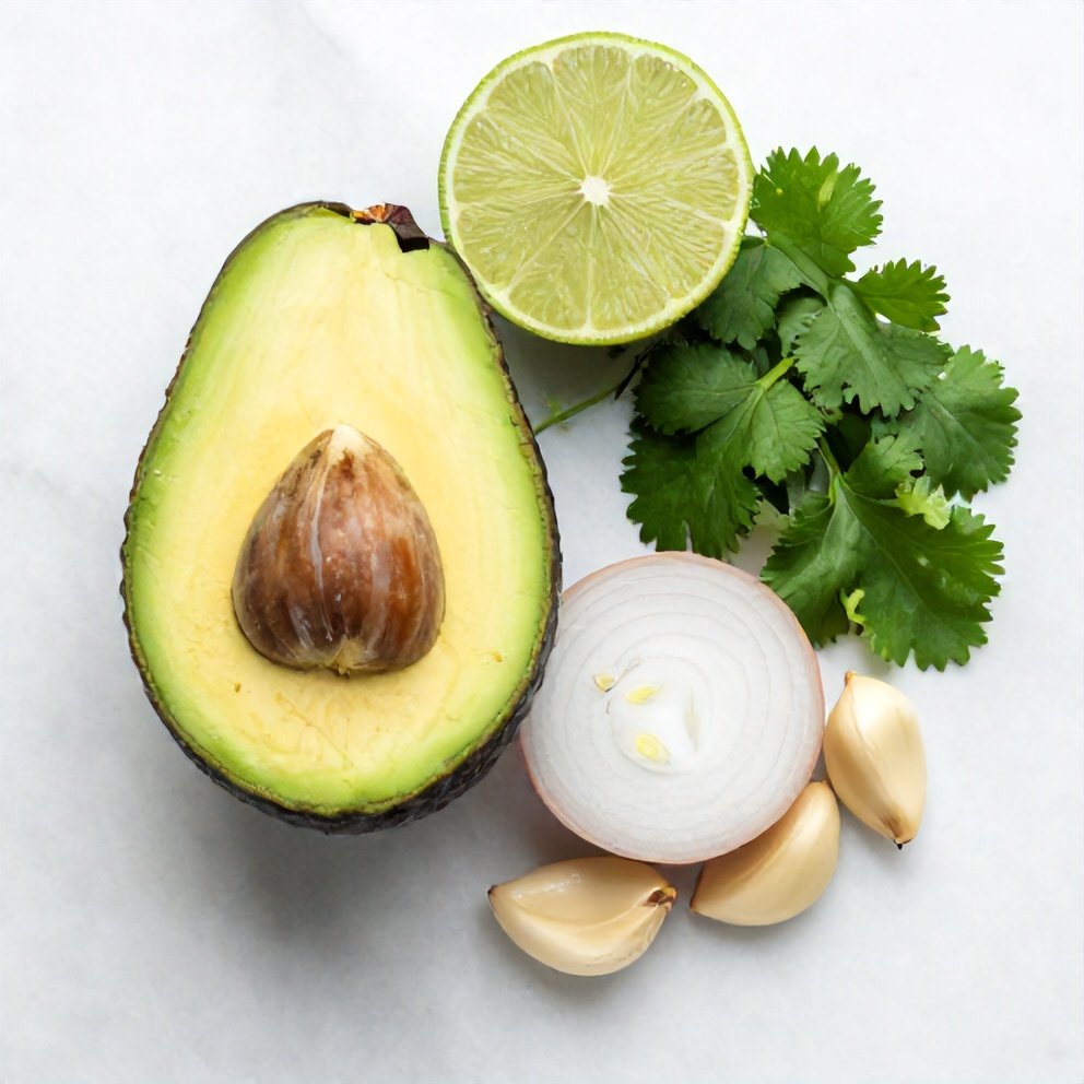 Avocado, lime, cilantro, onion, and garlic arranged on a white marble surface