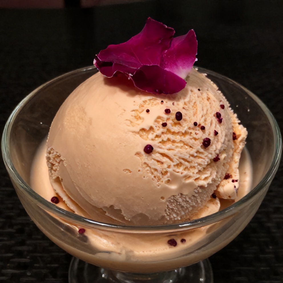 Rose Ice Cream served in a glass bowl with a sprig of rose